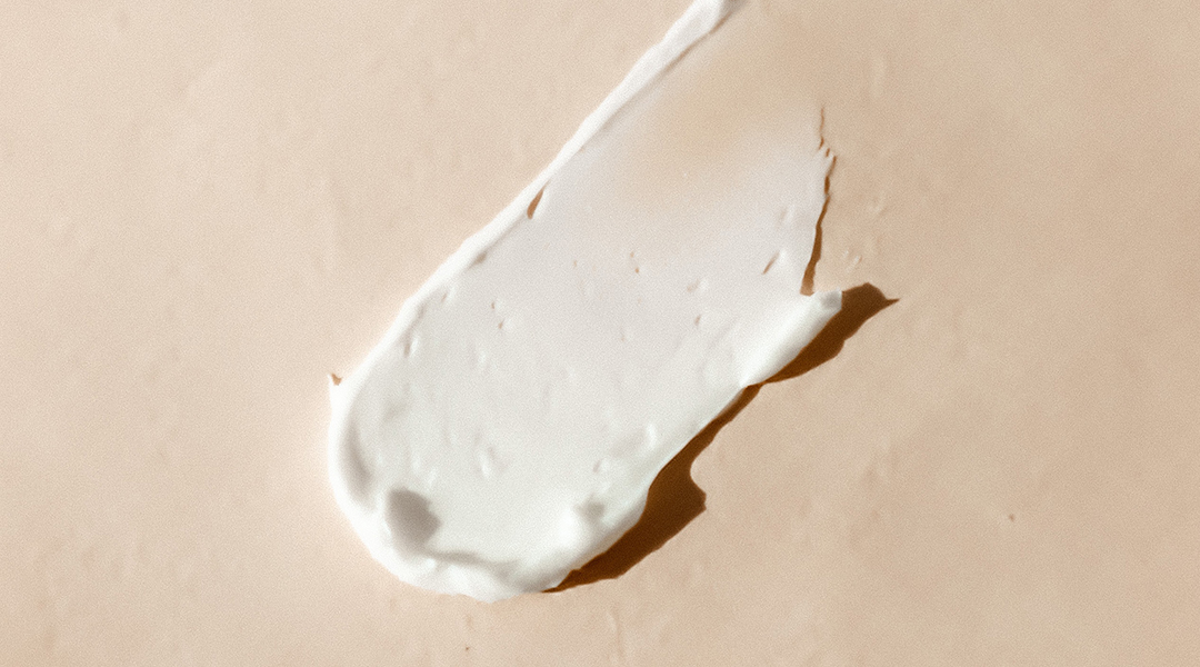 A slab of sunscreen on a beige surface.