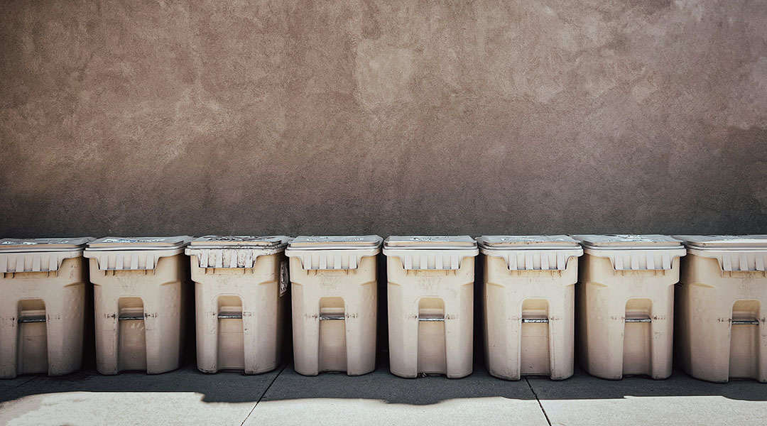 Garbage cans lined up in a row.