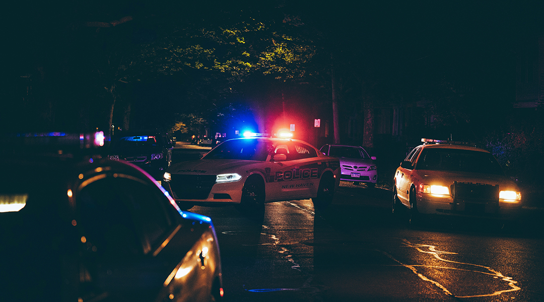 Police cars with their sirens on.