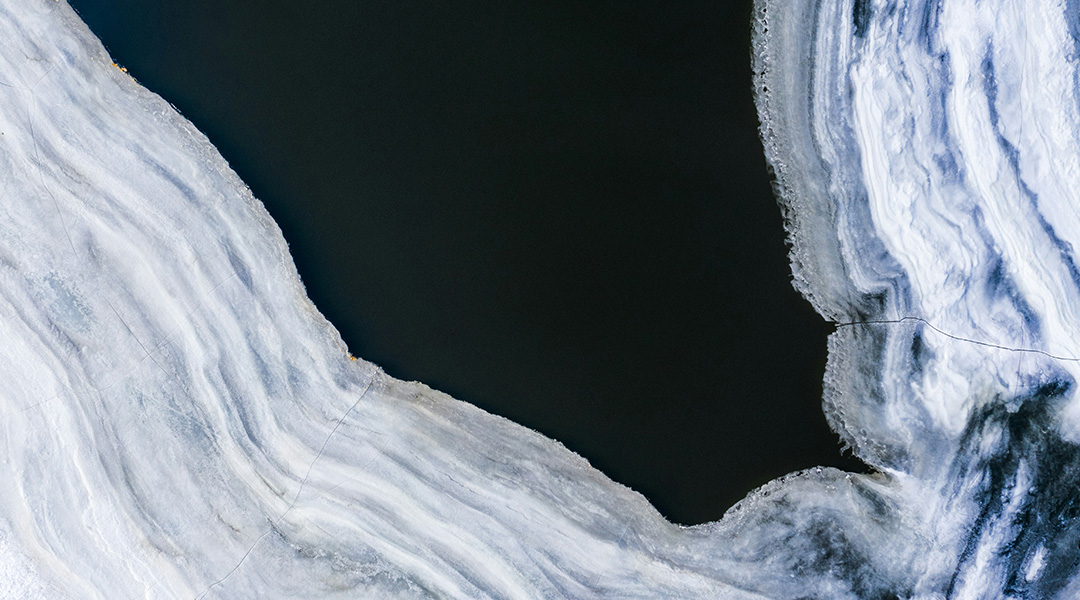 Arial image of an body of water and ice in winter.