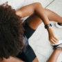 A woman in workout gear looking at her watch.