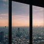 A city landscape through a sky scraper window.